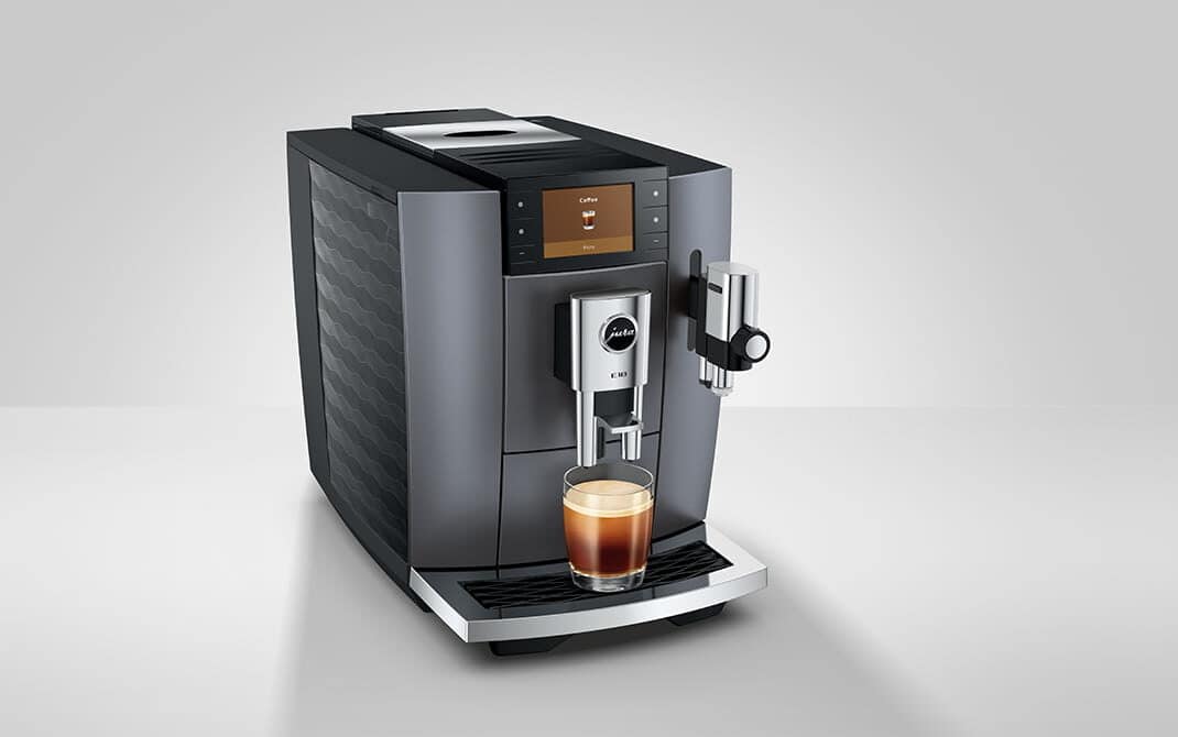 JURA E10 Onyx Grey van opzij, met een vers gezette Cold Brew