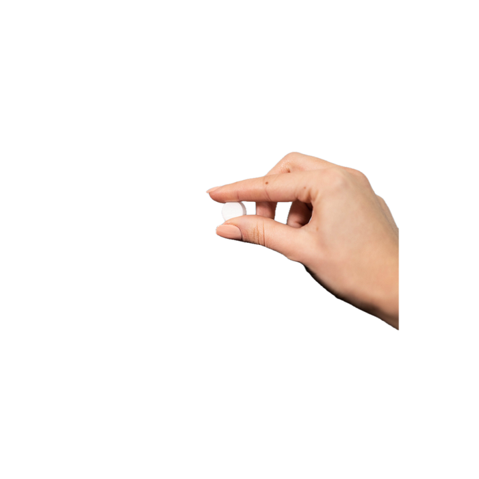 Hand met twee vingers die een kleine witte tablet vasthouden - Franke Reinigingstabletten | Arte dell' espressO