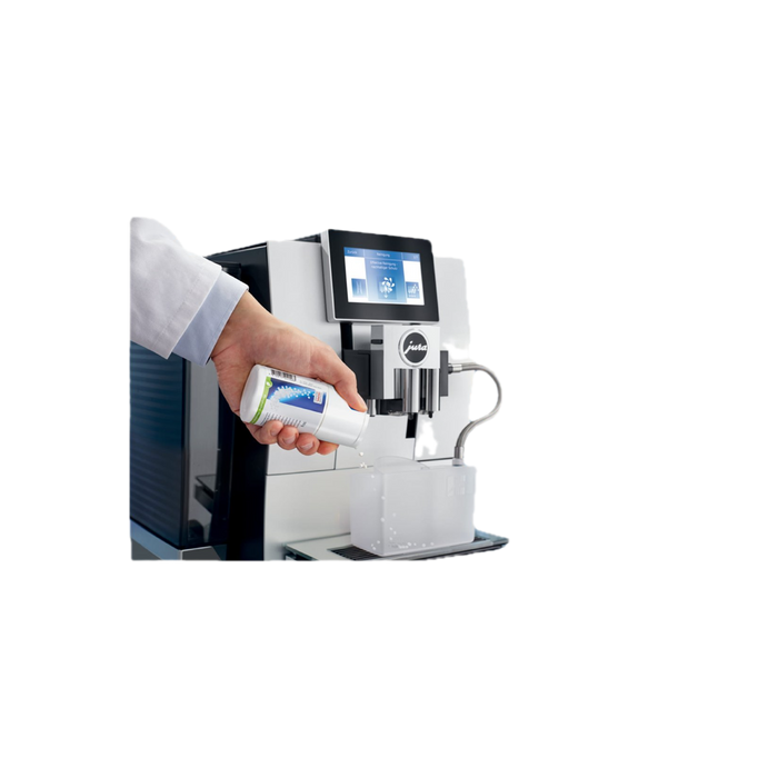 JURA melksysteemreiniger minitabletten 90g wordt in witte verpakking in koffiemachine gegoten | Arte dell' espressO