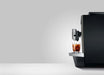 JURA X10c Dark Inox koffiemachine met glas koude koffie op het dienblad