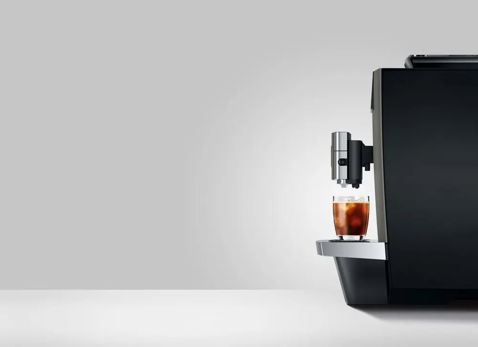 JURA X10c Dark Inox koffiemachine met glas koude koffie op het dienblad