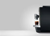JURA X10c Dark Inox koffiemachine met kopje koffie op zilveren lekbak