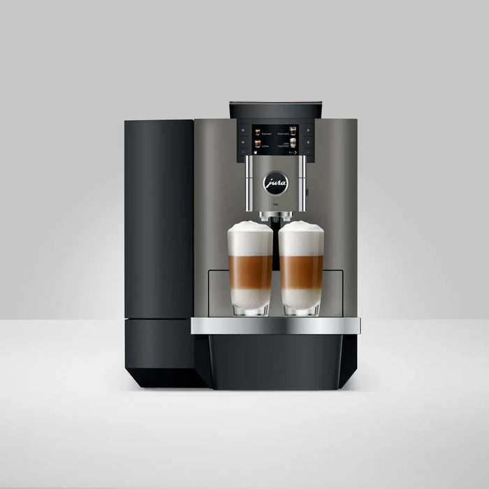 JURA X10c Dark Inox koffiemachine met twee glazen latte macchiato op het roestvrijstalen lekbakje