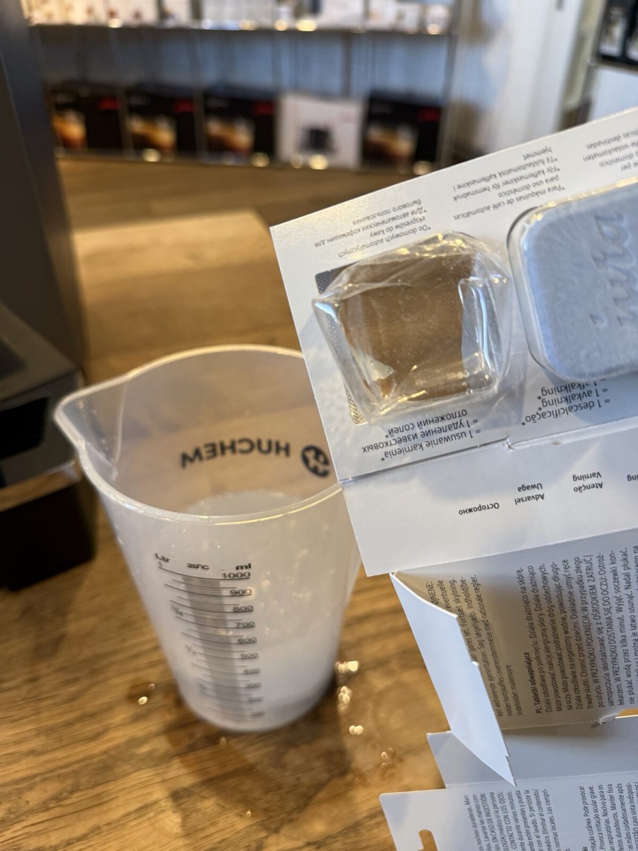 JURA ontkalkingstabletten in de maatbeker met lauw water